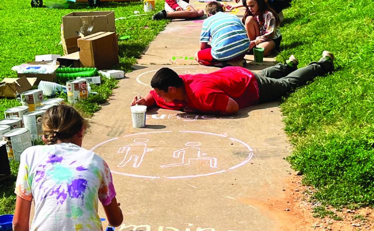 Sixth grade students and teachers at Maysville Elementary School painted outdoor activities on the sidewalks and concrete slabs of the school’s playground last week. Supplies for the Painted Playscape project were funded by a TSET grant awarded to Maysville Schools this year. School officials say the project is just one of many unique opportunities the grant has provided students. Courtesy photo
