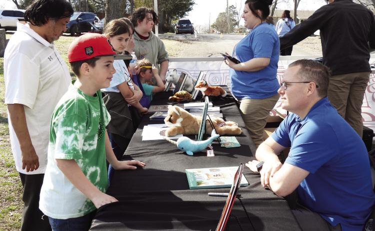 Author Wiley Barnes (seated right) visited with young readers and signed books during the community kick-off event for Stratford's Trails and Tales StoryWalk Saturday. Barnes' children's book 'Funny Fani'' is the featured title for Trails and Tales this month. The StoryWalk is located at Stratford's Town Park, Patterson and 7th Street. News Star photo by Chris Mackey