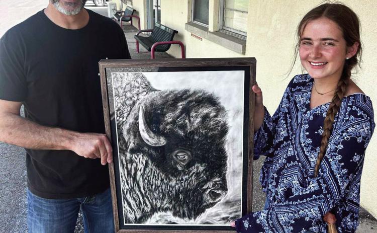 Katelyn Estes and her art teacher Shea Meyer display her charcoal piece “Spirit of the Plains.”