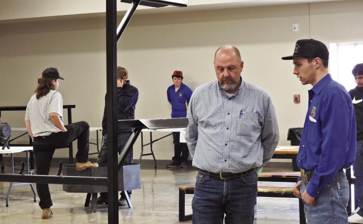 Stratford junior Jacob Owens (far right) explains his ag mechanics project entry to the contest judge. News Star photo by Chris Mackey
