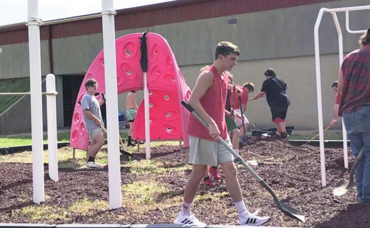 Maysville football players help spread mulch