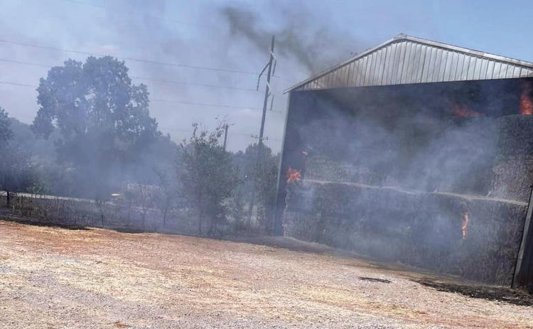 As temperatures continued to soar over 100 degrees this week, Maysville and Rush Creek Volunteer Fire Departments stood watch over a hay barn that caught fire Tuesday afternoon about a quarter mile south of Maysville on Hwy 74. The amount of hay inside the barn prevented fire crews from extinguishing the fire, which had to be treated as a controlled burn.