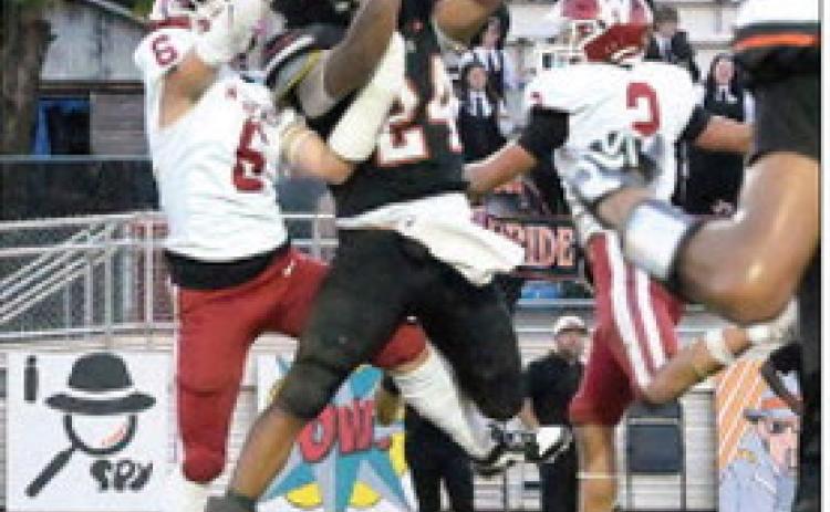 Wynnewood’s #6 Braylon Pierce and #2 Jett Anderson surround the Wewoka Tiger receiver as he makes the first down catch. Photo by Don Coffey