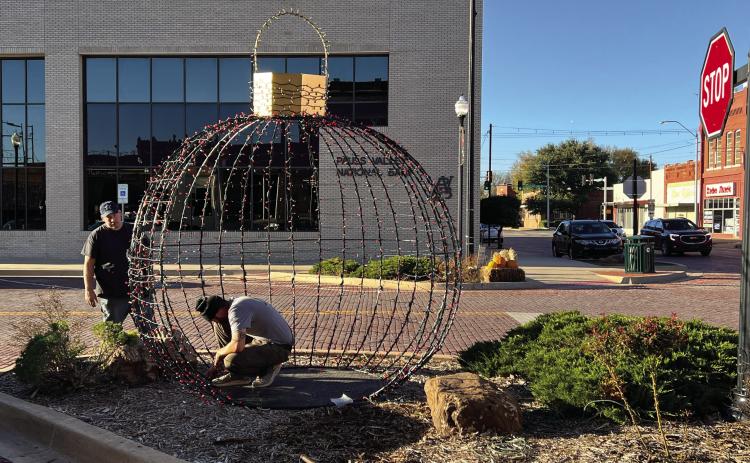 Pauls Valley city employees worked Wednesday to put the finishing touches on one of two 10-foot-by-10-foot wrought iron Christmas ornaments decorating the downtown area this holiday season. News Star photo by Suzanne Mackey