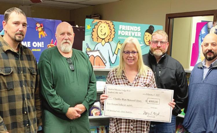 Chase Lutrell, Jeffery Stringer, Jeffrey Wright, and John-Paul Townsend of Stratford Masonic Lodge #118 present librarian, Teresia Jors (center), with a $4,000 check in support of library programming. Courtesy photo