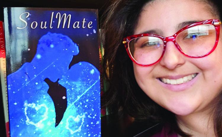 Local indie author Diana Mooney poses with her first published novel, “SoulMate.” Courtesy photo