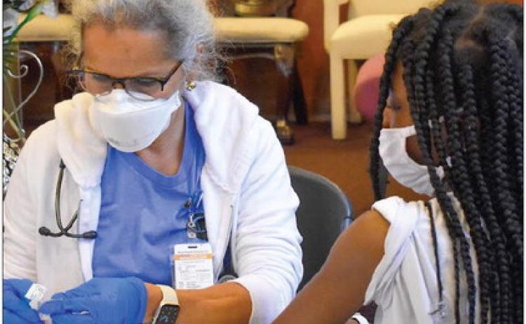 A nurse prepares to wipe a teenager's arm with an alcohol pad at a COVID-19 vaccination drive at Voice of Praise Baptist Church in Oklahoma City on Saturday, Sept. 25, 2021. (Rebecca Najera/Oklahoma Watch)