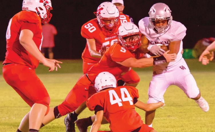 #5 Nigel Reid, #44 Holden Tyler and #50 Patricio Recendiz tackle the Comet runner during last week’s game. Photo by Kristy Schrader