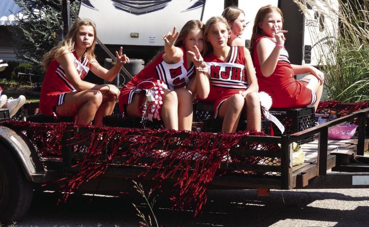 Maysville junior high cheerleaders strike a pose as they wait for the homecoming parade to begin last Friday.