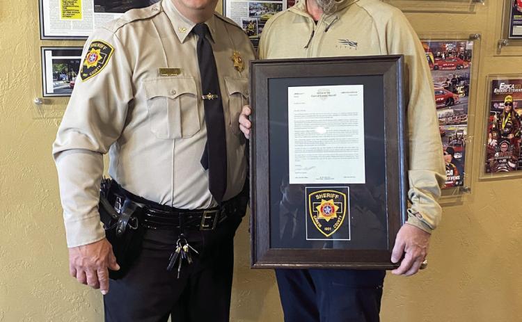Garvin County Sheriff Jim Mullett presents a letter of appreciation to local businessman Richard Freeman for providing a facility for law enforcement agencies to use as a command center during a recent manhunt near Wynnewood. Photo Courtesy of GCSO.