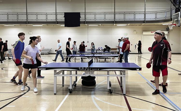 Menglin Hi (left), of Norman, serves the ball during a practice match with Dennis Rhodes (right), of Oklahoma City, and Imre Simonji, of Norman, at the Valley Paddle Battle Saturday.